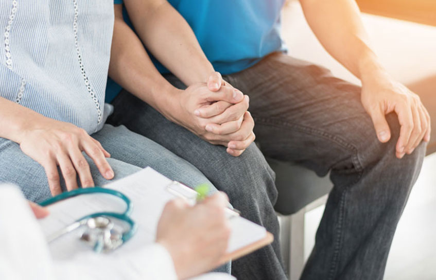 Couple holding hands at doctor's office