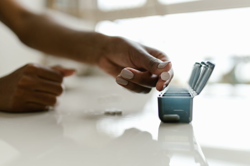 Hand placing pill in box